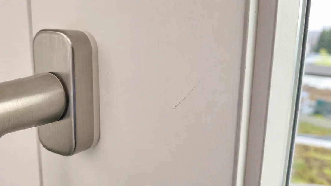 Feiner Kratzer neben dem Fenstergriff.