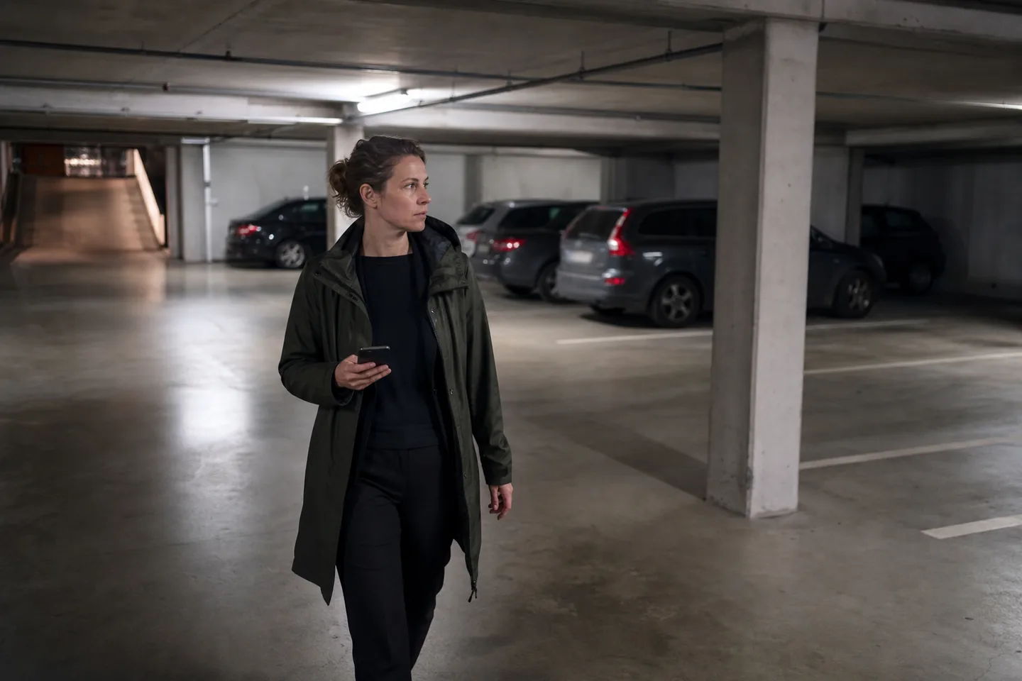 Hausverwalterin dokumentiert eine Tiefgarage mit dem Smartphone.